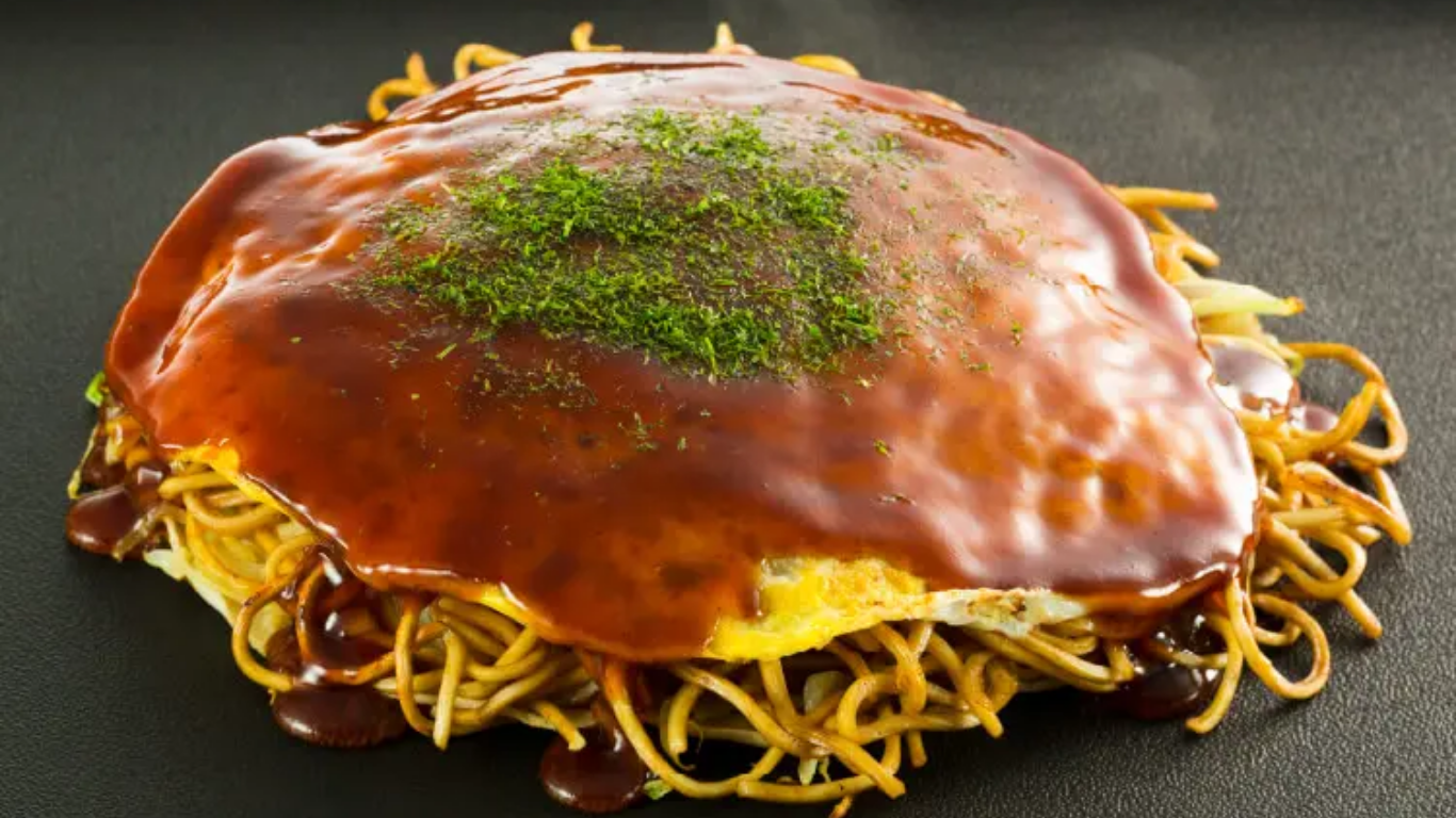 鉄板の上で焼かれる広島風お好み焼き