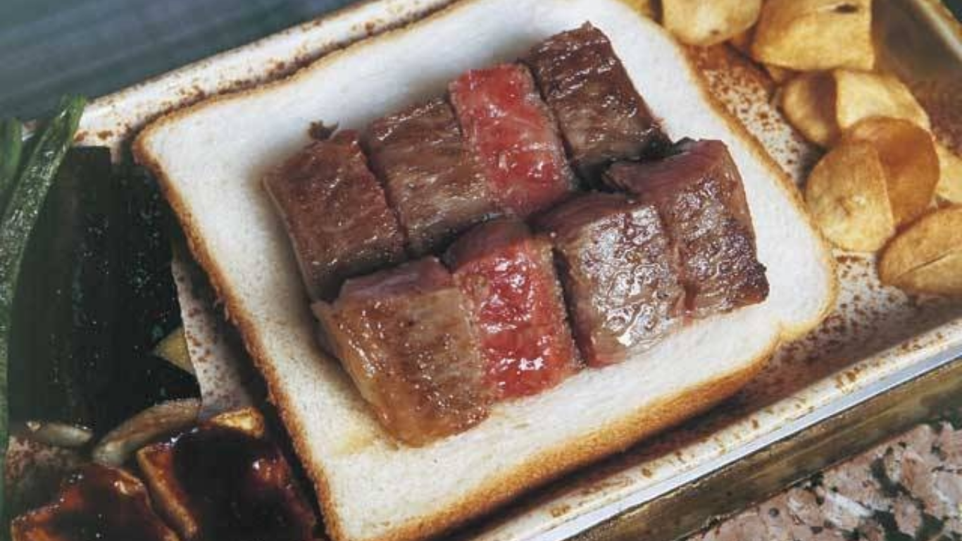 鉄板の上で焼かれる美しいサシの入った宮崎牛ステーキ