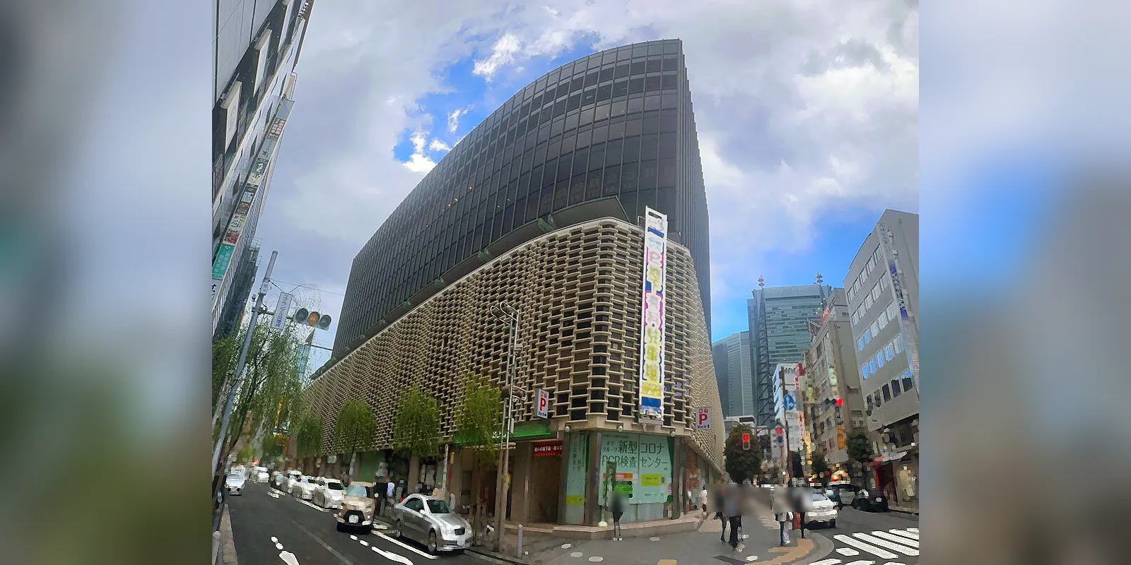 新橋駅前のニュー新橋ビル。白っぽい格子状の外壁の上に黒いガラス窓の高層部が載っている