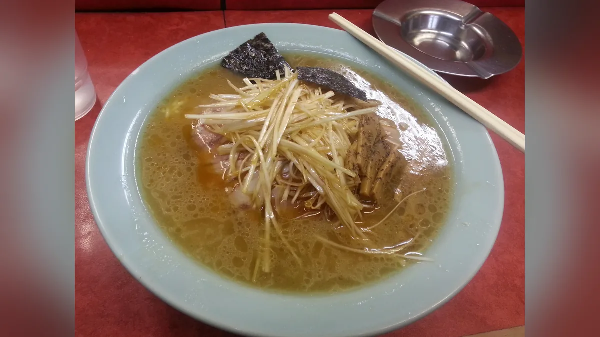 ラーメンショップのネギチャーシューメン。白濁したスープに、細く切って和えたネギが山盛りになっている